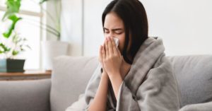 Woman Blowing Her Nose On Couch
