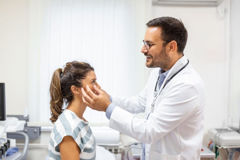 Adult woman having a visit at oculist's office doctor examining eyes of young woman in clinic