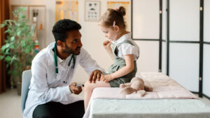 The best primary care doctors in Waterbury CT, portrayed by a photo of a doctor checking his young patient's knee