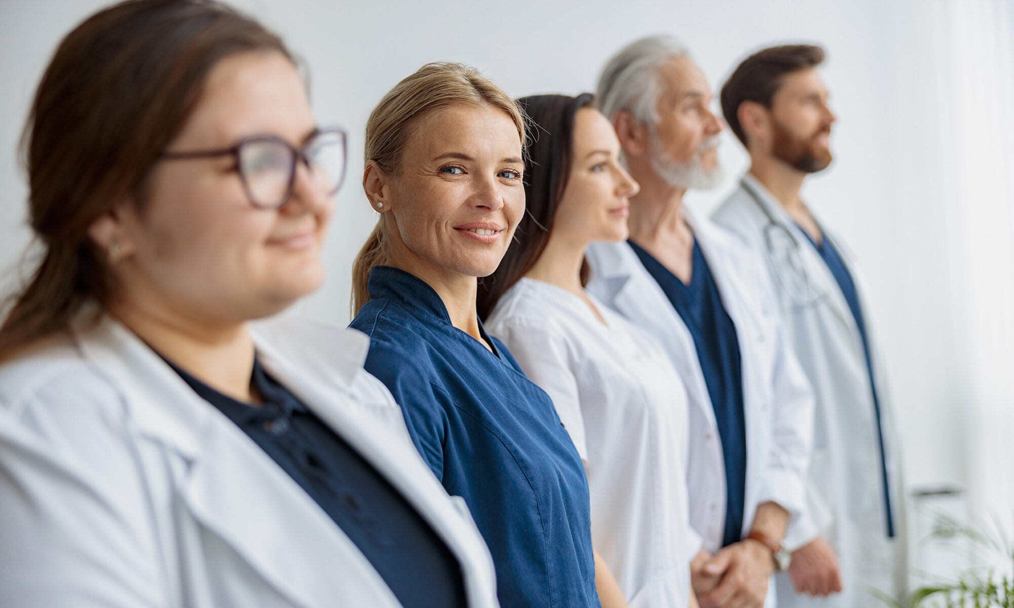Group of best primary care doctors in stamford ct in uniform standing in a line at the modern clinic