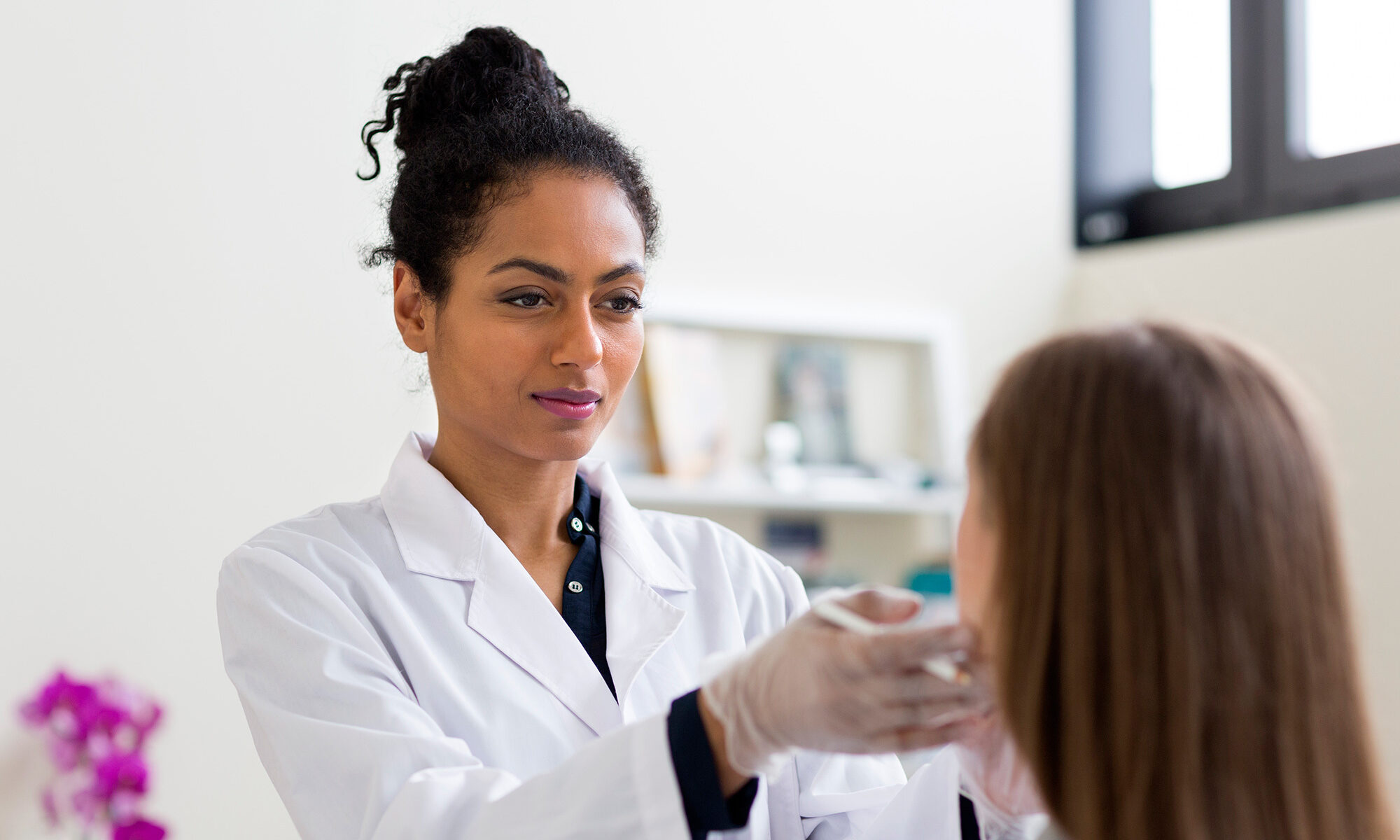 Ethnic female doctor examins patient as one of the best allergy doctors in bridgeport