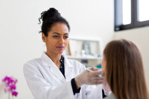 Ethnic female doctor examins patient as one of the best allergy doctors in bridgeport